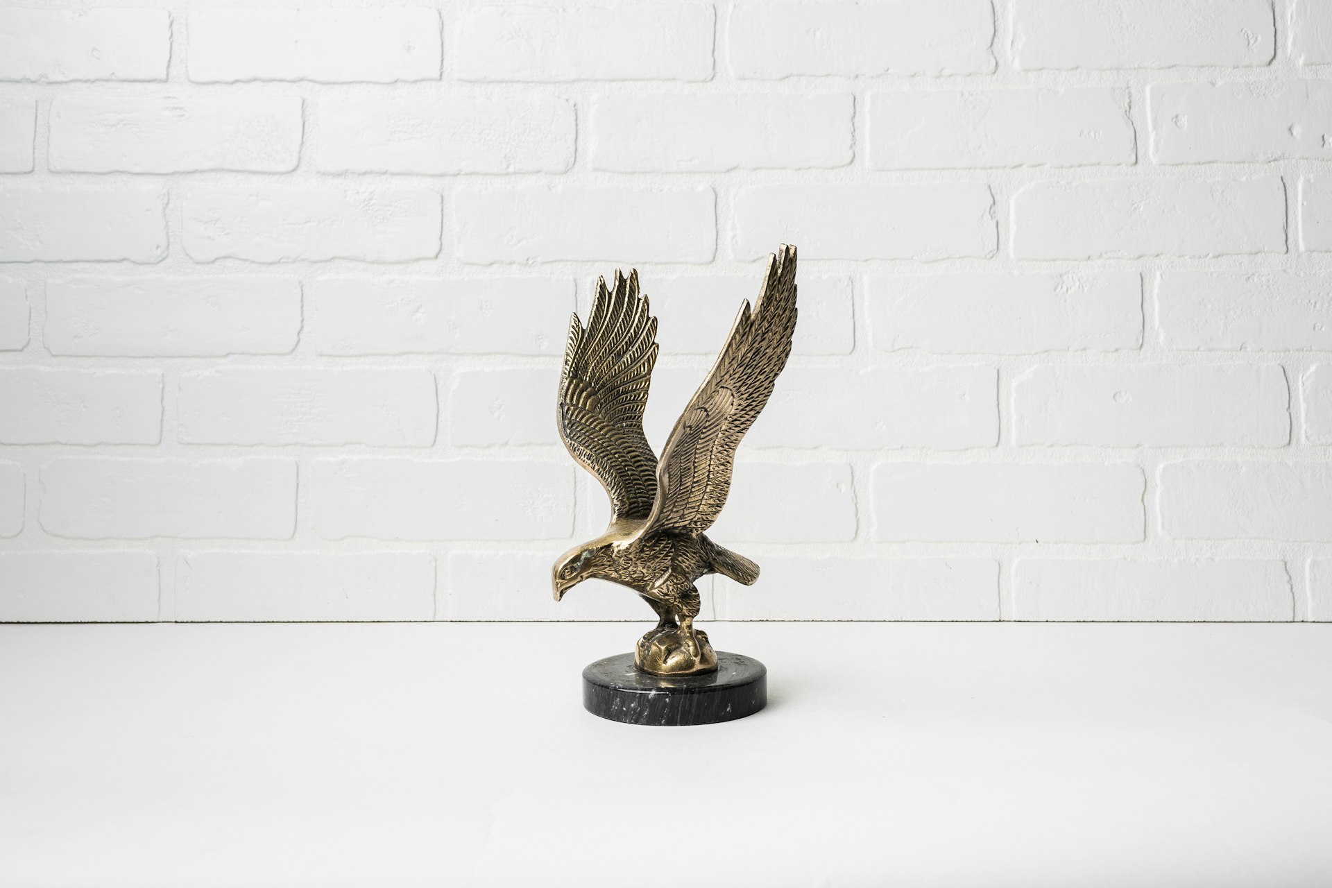 a bronze statue of an eagle on a black base
